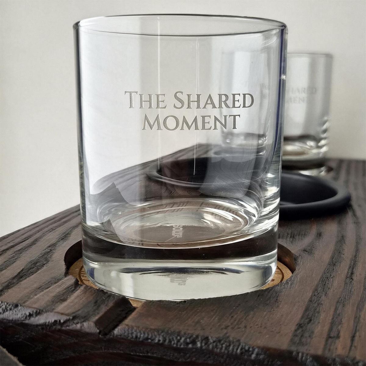 Close-up van twee gegraveerde whiskyglazen op The Shared Moment serveerplank voor twee.