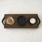Bovenaanzicht van The Evening Ritual met glas, zwart schaaltje en kaars in de houten uitsparingen