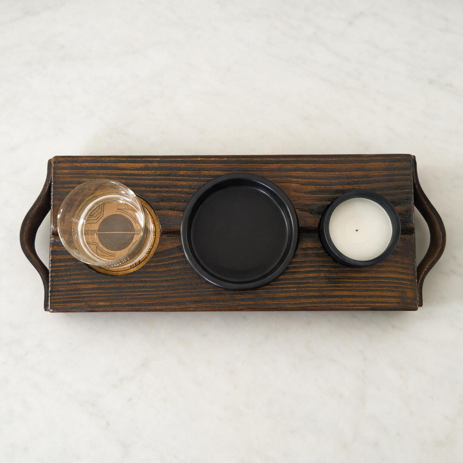 Bovenaanzicht van The Evening Ritual met glas, zwart schaaltje en kaars in de houten uitsparingen