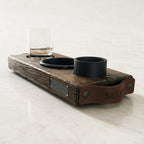 The Evening Ritual van donker massief hout met leren handgrepen, gegraveerd glas, zwart schaaltje en kaars op wit steen
